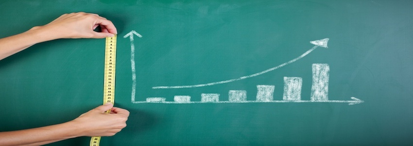 Closeup of woman's hands measuring bar graph with tape on blackboard.jpeg Closeup of woman's hands measuring bar graph with tape on blackboard.jpeg